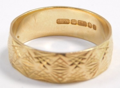 An 18ct gold wedding band, with engraved and faceted decoration, size R, 4.9g. - 2