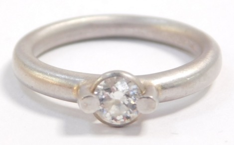 A platinum and diamond solitaire ring, in a pinned rub over setting, approximately 0.4cts, size L, 6.3g.