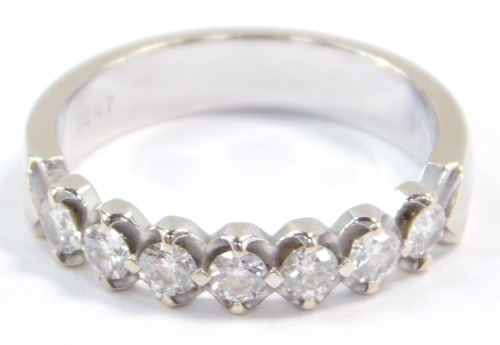 A diamond seven stone half hoop eternity ring, set in white metal, stamped 18k, approximately a 0.25ct, size M, 3.5g.