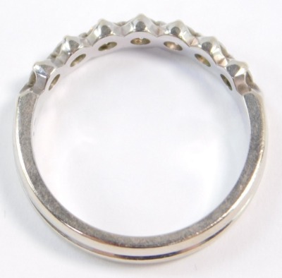 A diamond seven stone half hoop eternity ring, set in white metal, stamped 18k, approximately a 0.25ct, size M, 3.5g. - 3