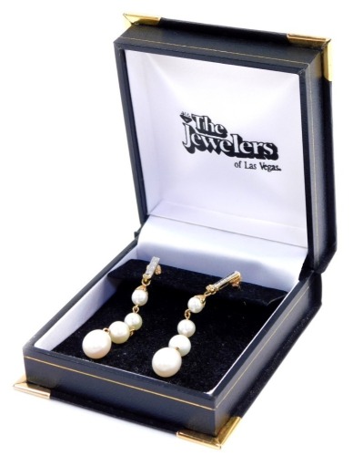 A pair of cultured pearl and diamond drop earrings, each earring set with four graduated pearls, in yellow metal stamped 14K.