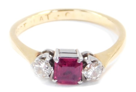 An 18ct gold ruby and diamond three stone ring, the diamonds approximately 0.25ct, size L, 2.7g.