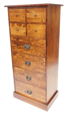 An Eastern hardwood narrow chest of drawers, for Laura Ashley, with a plank top above an arrangement of four short and four long drawers, with metal handles, on a plinth, 146cm high, 67cm wide, 47cm deep.