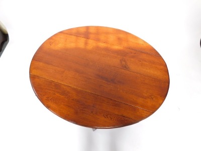 An oak drop leaf coffee table, with an oval top on turned supports, 115cm wide. - 3