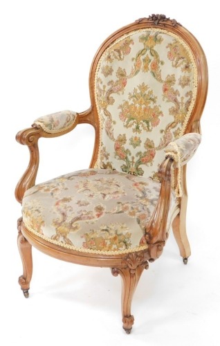 A Victorian rosewood show frame armchair, the moulded spoon shape back carved with flower heads, with a padded back, arm rests and seat in textured and patterned velvet, the arms with scroll carved supports, on cabriole legs, headed by leaf carving.