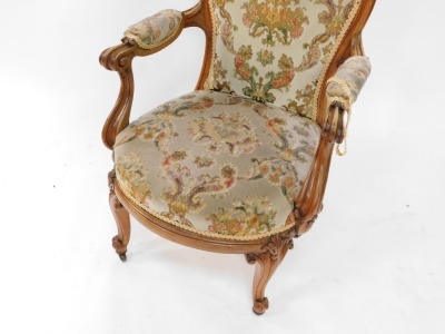 A Victorian rosewood show frame armchair, the moulded spoon shape back carved with flower heads, with a padded back, arm rests and seat in textured and patterned velvet, the arms with scroll carved supports, on cabriole legs, headed by leaf carving. - 3