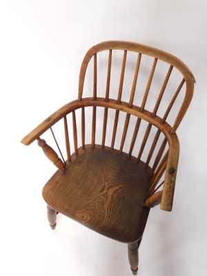 A 19thC ash and elm Windsor chair, the shaped back and arms with spindle turned supports, with solid seat on turned legs with H stretcher. (AF) - 2