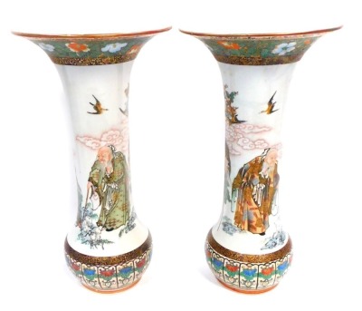 A pair of Japanese Kutani porcelain vases, with flared rim and enamelled and gilt diaper work borders, and the bodies having seated figures, standing sages, etc, on bulbous base with eight character iron red signature, 36cm high. (AF)