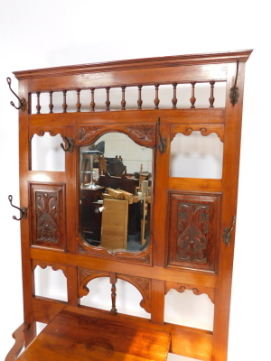 A Victorian walnut hall stand, with a central cartouche shaped mirror, with bevelled plate, surrounded by foliate carved panels, cast hooks, etc., the base with a frieze drawer, flanked by recesses for umbrellas, each with a metal liner, 106cm wide. - 2