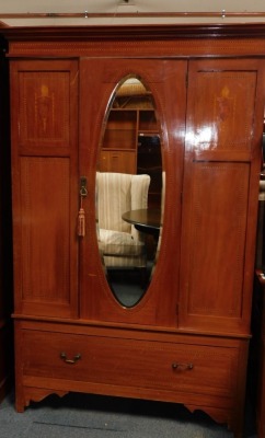 An Edwardian mahogany three piece bedroom suite, comprising wardrobe with oval bevelled mirror plate and a drawer, 130cm wide, a dressing table with oval bevelled plate, four trinket drawers and two long drawers, on brass castors, 101cm wide, and a washst - 2