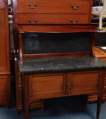 An Edwardian mahogany three piece bedroom suite, comprising wardrobe with oval bevelled mirror plate and a drawer, 130cm wide, a dressing table with oval bevelled plate, four trinket drawers and two long drawers, on brass castors, 101cm wide, and a washst - 4