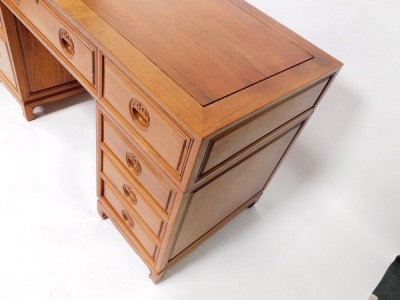 An Oriental hardwood desk, with a paneled top above an arrangement of nine drawers, each with recessed carved handles, on bracket feet, 79cm high, 137cm wide. - 4