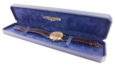 A Longines gentleman's gold plated wrist watch, circular champagne dial with centre seconds, date aperture, dial bearing a crown and Arabic script, on a leather strap, cased, proportedly presented by His Late Majesty The King of Jordan.