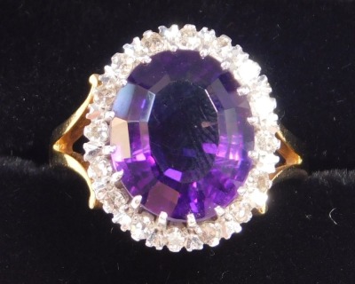 A 18ct gold and amethyst ring, oval cut in a surround of diamonds, amethyst approximately 5ct, size K/L, 6.5g.