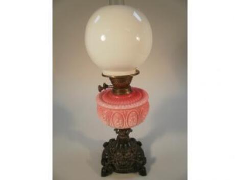 A Victorian oil lamp with pink glass moulded reservoir with flower medallions