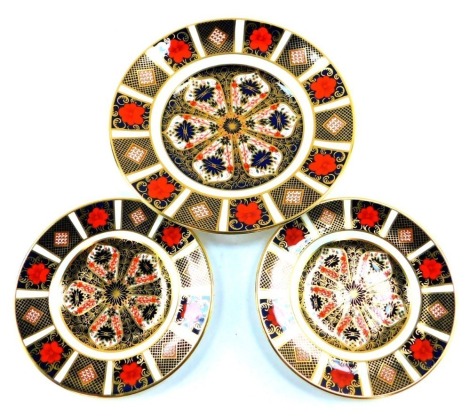 Three Royal Crown Derby Old Imari pattern cabinet plates, comprising two small 1128 pattern, seconds, and one medium 1128 pattern, 16cm diameter and 22cm diameter. 