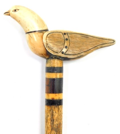 A 19thC walking cane, with a marine ivory handle carved as a dove of peace, mounted on a slim whale bone shaft, with baleen rings, 89cm high.