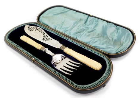 A pair of Victorian silver plated fish servers, with engraved floral and foliate decoration with ivory handles, cased.