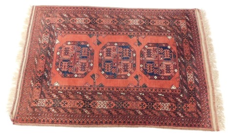 A Tekke rug, red ground decorated with three central guls, in repeating geometric borders, 153cm x 105cm.