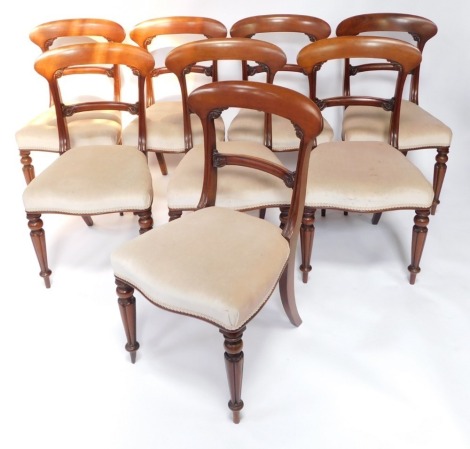 A set of eight Victorian mahogany dining chairs, each with a shaped leaf carved bar back, a padded serpentine fronted seat, on turned and fluted legs.