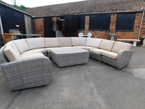 An extensive Four Seasons outdoor rattan garden suite, comprising two end single seats, four single seats, two curved sections and a coffee table, with cushions, made to seat 8-10 people.