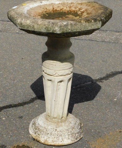 A reconstituted stone birdbath, with octagonal top on column with a rounded plinth base, 65cm high, 45cm wide.