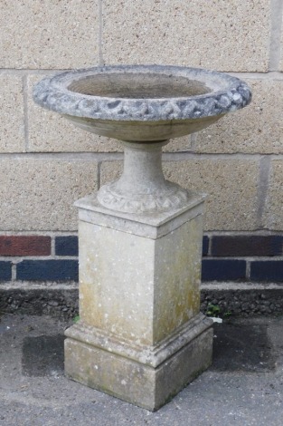 A reconstituted stone bird bath, the circular bird bath top with fluted column supports on a block base, 80cm high, 50cm wide.