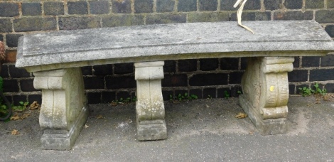 A reconstituted stone curved garden bench, the rectangular curved top on three scroll plinths, 49cm high, 143cm wide, 40cm deep.