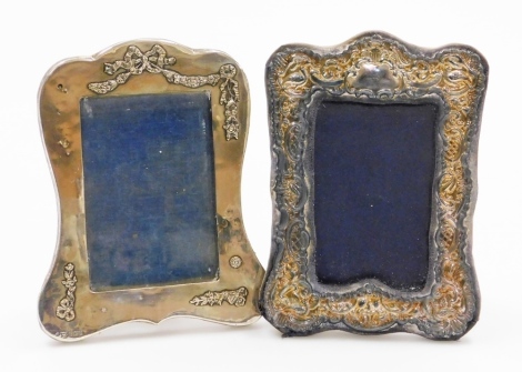 An Edwardian silver photograph frame, with repousse cherub and foliate scroll decoration, Birmingham 1908, 12.5cm x 8cm, and another Edwardian silver photograph frame, Birmingham 1906, 13cm x 9cm, (both AF). (2)