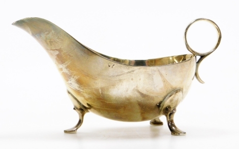 A George V silver sauce boat, with ring handle and fluted stem on tripod base, Sheffield 1920, 8¾oz.