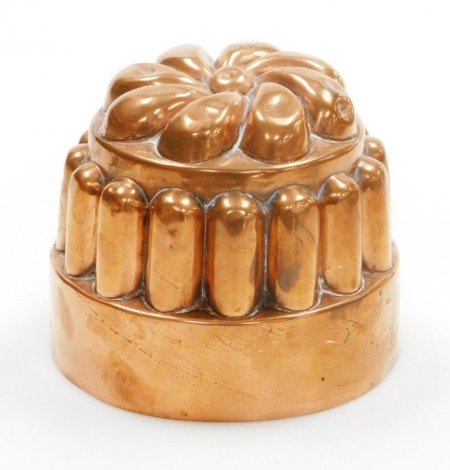 A Victorian copper jelly mould, the top with flower design, on reeded supports, on a circular base, numbered 20, 11cm high, 13.5cm diameter.