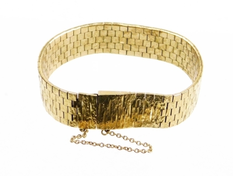 A 9ct gold bracelet, of articulated link form with bark effect finish, and safety chain, 43.9g.