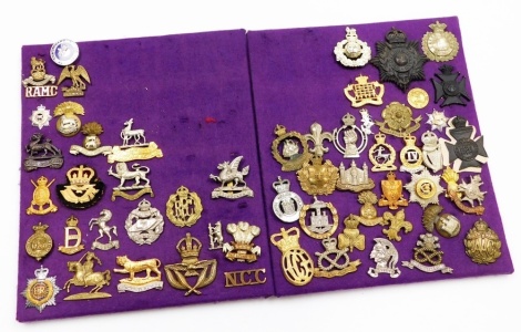 A collection of military cap badges, including some reproductions, including Lancs Hussars, Cambridgeshire Regt, Leicestershire Regt, Royal Munster, RFC, Tank Corps, etc., two panels, approximately 55.