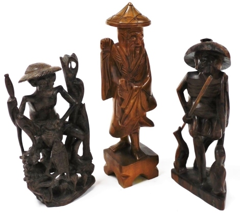 Tribal Art. Three eastern carved wooden fisherman, 31cm, 25cm and 23cm high.