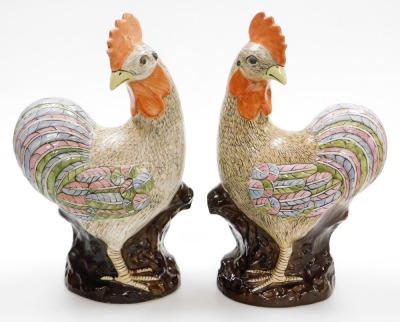 A pair of late 20thC Chinese pottery figure of cockerels, with enamelled decoration, 49cm high.