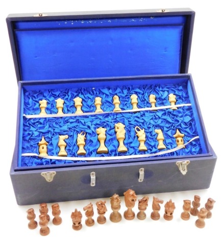 An Eastern carved wood chess set, with various monkey, elephant, horse and lion figures, in a blue velvet lined case, with lid, 17cm high, 53cm wide, 29cm deep.