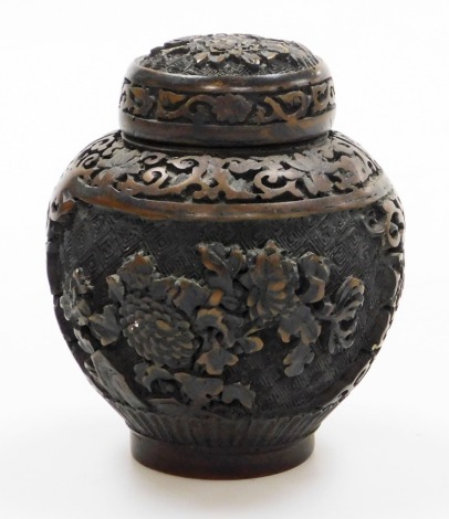 A Chinese composition jar and cover, decorated in high relief with panels of chrysanthemums between scrolling borders, 11cm high.
