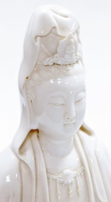 A Chinese blanc de chine figure of Guan Yin seated on a lotus and wave base, impressed mark to the rear, 46cm high. (AF) - 13