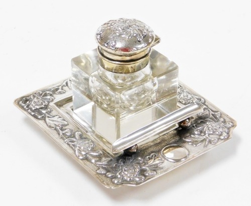 A Chinese silver ink stand, the cut crystal well having a repoussé decorated cover, the square stepped base with floral decoration pen rest, makers mark 'YOK SANG' to base, 11cm square. Yok Sang is thought to have been based in Shanghai and was active at