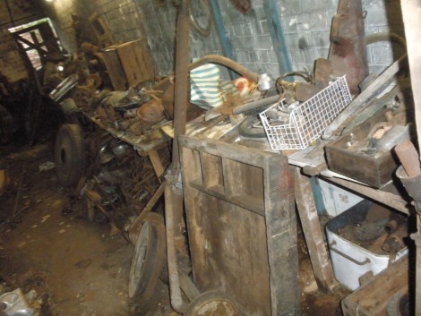 Vintage car parts and automobilia, comprising of vintage jacks, pulleys, air filters, gearboxes, cylinder heads, dashboards, doors and Ford Pop rear axle doors, All situated in the middle store, five benches on right hand side, plus floor below.