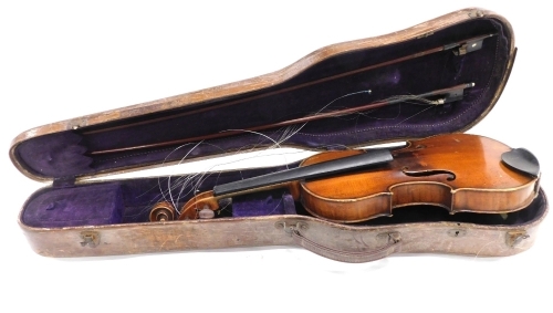 A late 19thC/early 20thC violin, with a two piece back, length of back 36cm, sold with a bow and a hardwood veneered case.