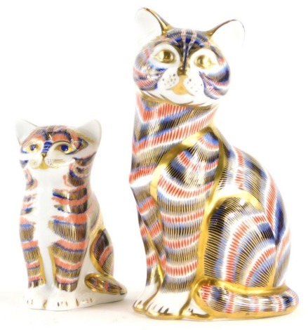 Two Royal Crown Derby porcelain paperweights of cats, with silver coloured stoppers, the largest 12cm high. (2)