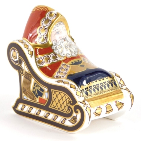 A Royal Crown Derby porcelain paperweight of Santa Claus in a sleigh, with silver coloured stopper, 10cm high, boxed.