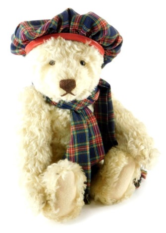 A Steiff teddy bear, wearing a tartan hat and scarf, 35cm long.