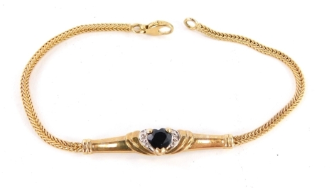 A 9ct gold bracelet, with central dark blue heart cut stone, surrounded by CZ stones, on a bar design, with weave design bracelet, yellow metal stamped 375, 19cm long, 4.9g all in.