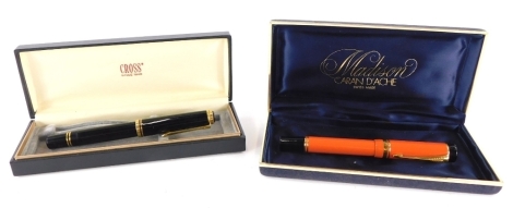 A Parker orange and black Duofold fountain pen, and a Pelican fountain pen.