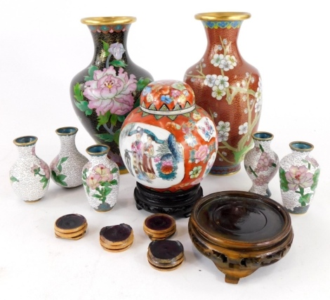 A group of Chinese ceramics, to include a modern jar and cover, five white cloisonne finish vases, a black finish cloisonne and gilt picked out vase, 22cm high and a similar example on a red backing, 22cm high, with a group of hardwood stands. (a quantity