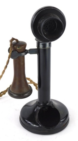 A black metal candlestick cased telephone, with brown Bakelite earpiece.