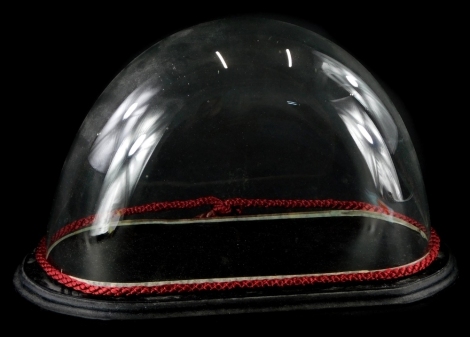 A small glass dome, on ebonised base, 19cm high, 32cm wide.