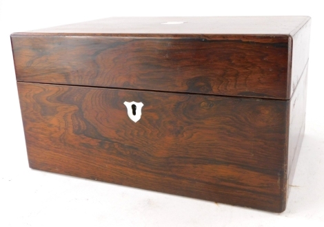 A Victorian rosewood workbox, the hinged lid with a vacant shield shaped cartouche enclosing fitted interior with two scent bottles, removable tray, etc., 30cm wide.